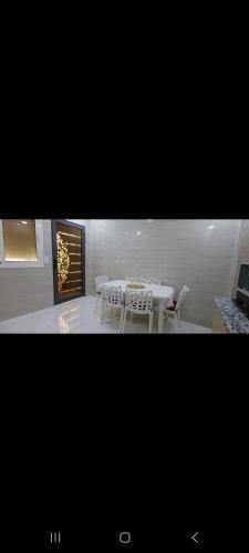 a dining room with a table and white chairs at Villa de luxe in Imouzzer Kandar