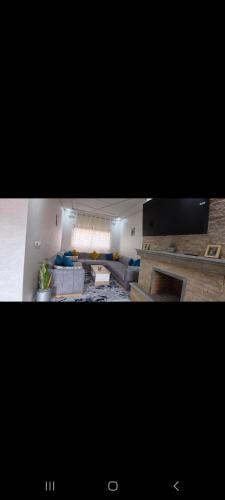 two pictures of a living room with a couch at Villa de luxe in Imouzzer Kandar
