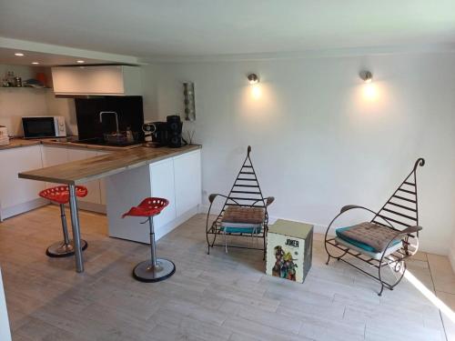 une cuisine avec des chaises, une table et un comptoir dans l'établissement Chez Nina - vue mer, à Mandelieu-la-Napoule