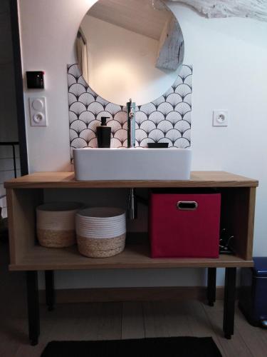 une vanité de salle de bain avec un lavabo et un miroir dans l'établissement Gîte L'hélice, à Douvres
