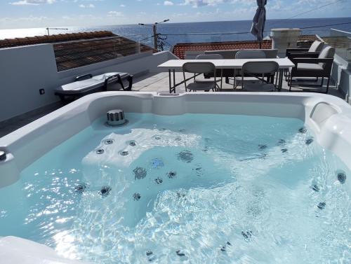 a jacuzzi tub on the roof of a house at Pauloldtown - Local experience w rooftop n jacuzzi in Paul do Mar
