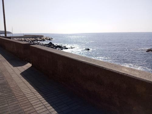 a walkway next to the ocean with the ocean gmaxwell gmaxwell gmaxwell at Pauloldtown - Local experience w rooftop n jacuzzi in Paul do Mar
