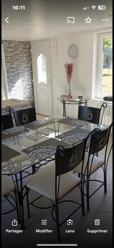 une salle à manger avec une table et des chaises en verre dans l'établissement Gîte ALRA 3 chambres, à Manneville-ès-Plains