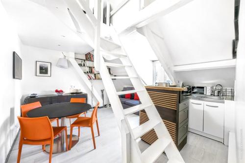 - un escalier en colimaçon dans une cuisine avec une table et des chaises dans l'établissement Gaité - Comfort & Convenience Montparnasse 1bdr, à Paris