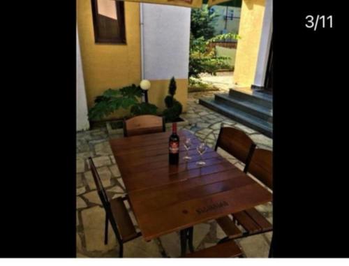a wooden table with a bottle of wine on it at Come here in Kuchkisabano