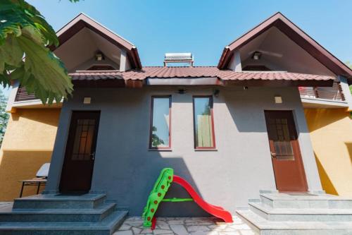 a small house with a slide in front of it at Come here in Kuchkisabano