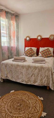 une chambre avec un grand lit avec une tête de lit rouge dans l'établissement T2 Dernier Étage avec Terrasse 5 min de la Mer, à Nice