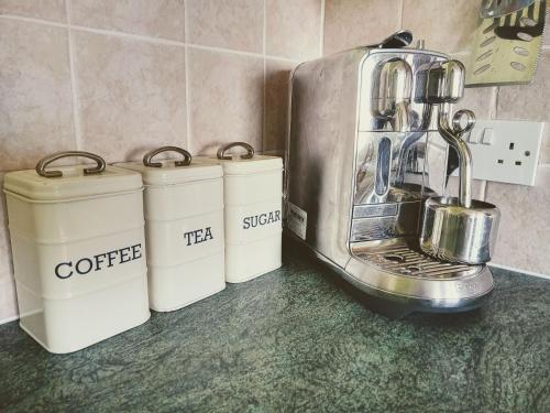 a kitchen counter with a coffee maker and three trash cans at Atlantic Point Stunning Sea View in Bundoran