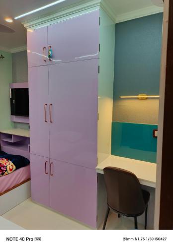 a bedroom with a desk and a pink closet at Chitta Jyoti Home Stay in Silchar