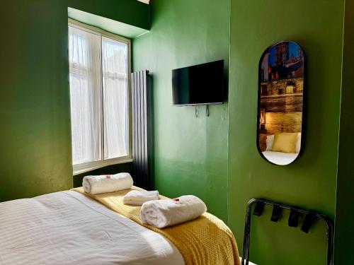 a green bedroom with a bed and a mirror at The Crescent York in York