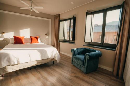a bedroom with a bed and a chair and windows at El Niu de Martinet in Martinet