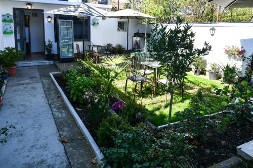 un jardín con mesa y sillas frente a una casa en Hostel 2VB, en Shkodër