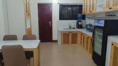 a kitchen with a table and a black refrigerator at KBC ZAI Baguio Staycations 3 & 4 in Baguio