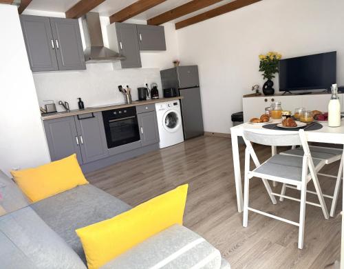 - un salon avec une cuisine et une table avec un canapé dans l'établissement Cocon Urbain- 30m des Allées Paul Riquet, à Béziers