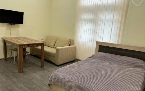 Un dormitorio con un sofá, una mesa y una cama. en Квартира, en Ereván