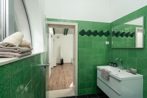 a green bathroom with a sink and a mirror at Vila Agava, Konavle in Gruda