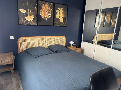- une chambre avec un lit doté de draps bleus et de miroirs dans l'établissement Pavillon neuf CREANCES plage, à Créances
