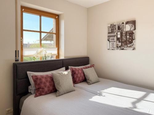 a bedroom with a bed with red pillows and a window at Apartment Wohlfühlplatzl - urgemütlich & ruhig in Vogtareuth