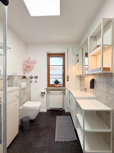 a white bathroom with a sink and a toilet at Apartment Wohlfühlplatzl - urgemütlich & ruhig in Vogtareuth