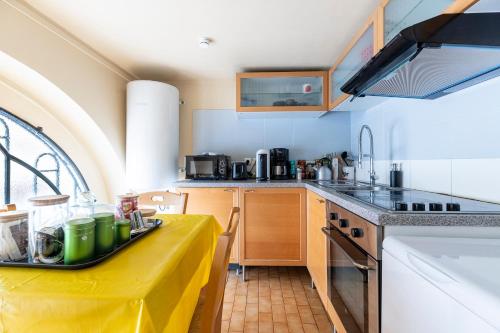 une cuisine avec une table et un chiffon de table jaune dans l'établissement Charmant studio Père Lachaise, à Paris