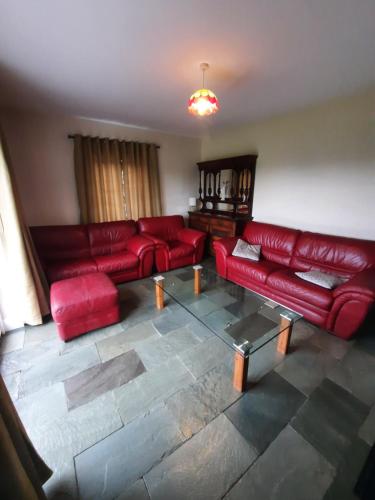 a living room with red couches and a table at Clone manor Lodge in Ballyragget