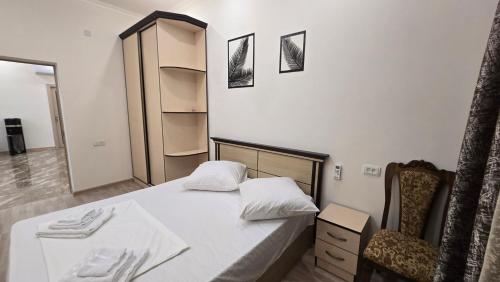 a small bedroom with a bed and a chair at Alyona's house in Vagharshapat
