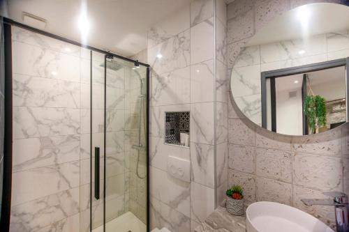 a bathroom with a shower with a sink and a mirror at Entre plages et centre-Ville in La Ciotat