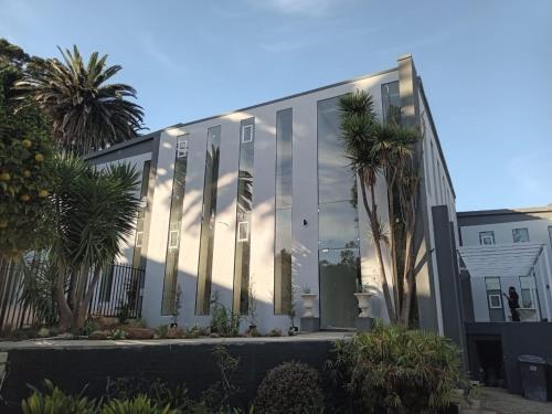 un edificio de cristal con palmeras delante de él en Retro Boutique, en Ciudad del Cabo