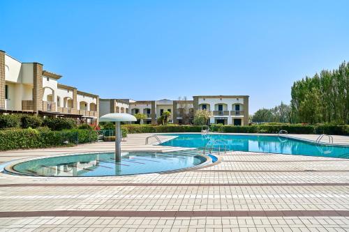 einen Pool mit Sonnenschirm im Innenhof in der Unterkunft Caorle Oasis Beach House - Host Solution in Caorle