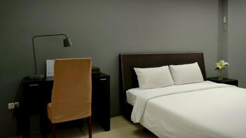 a bedroom with a bed and a desk and a chair at Centric Place Hotel in Bangkok