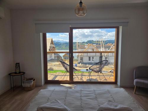 a room with a large sliding glass door with a view at Apartamenty TAFLA nad Jeziorem Czorsztyńskim in Kluszkowce