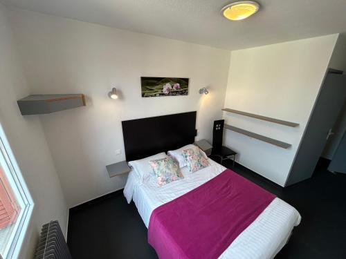 - une petite chambre avec un lit et une couverture rose dans l'établissement CHAMBRE PRIVE PROCHE de LA GARE SNCF, à Langeac