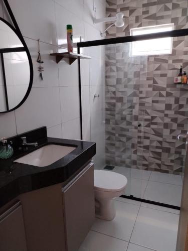a bathroom with a sink and a toilet and a mirror at Casa Sossego in Marechal Deodoro