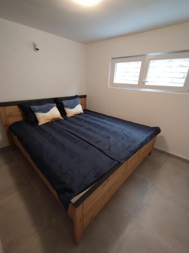 a large bed in a room with two windows at Beautiful Holiday House in Murter