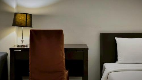 a hotel room with a bed and a table with a lamp at Centric Place Hotel in Bangkok