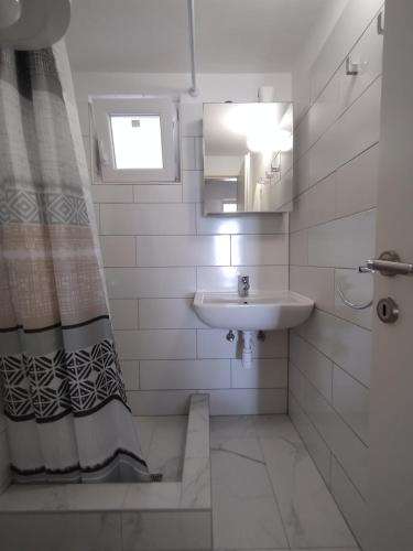 a white bathroom with a sink and a mirror at Beautiful Holiday House in Murter
