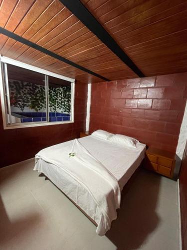 a bed in a room with a brick wall at Apartamento Carmen de Ápicala in Carmen de Apicalá