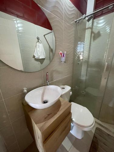 a bathroom with a sink and a toilet and a mirror at Apartamento Carmen de Ápicala in Carmen de Apicalá