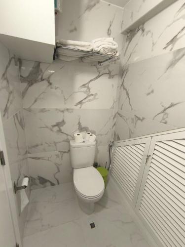 a bathroom with a toilet and marble walls at Villa Supranee Paradise in Câmara de Lobos
