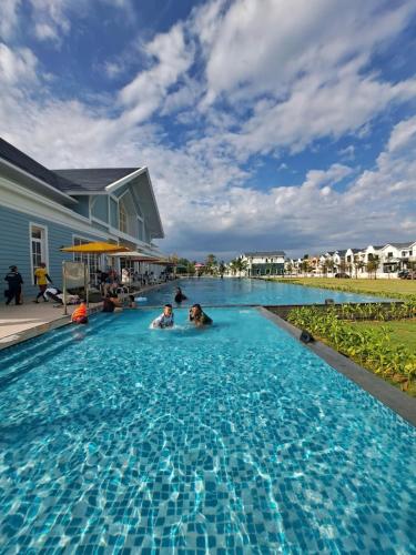two people swimming in a swimming pool at Phan Thiết Villa Novaworld in Bình Tú