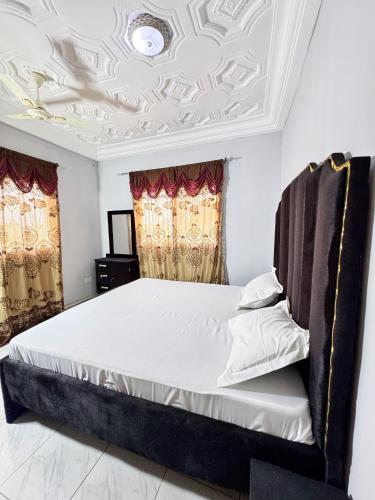 a bedroom with a bed with a coffered ceiling at Paradise Holiday home in Busumbala
