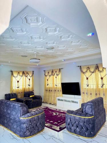 a living room with two couches and a flat screen tv at Paradise Holiday home in Busumbala