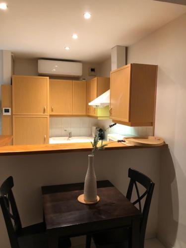 - une petite cuisine avec une table et un vase dans l'établissement Merimee 3D, à Cannes