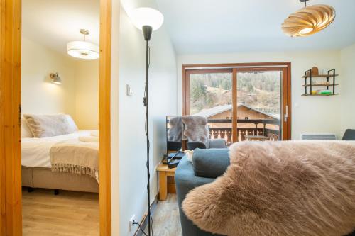 Cette chambre dispose d'un canapé, d'un lit et d'une fenêtre. dans l'établissement Perfectly placed petite pad!, à Morzine