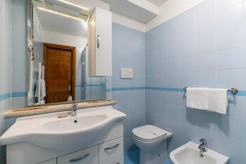 a blue bathroom with a sink and a toilet at Torre dell'orologio Apartment by Bricola Apartments in Venice