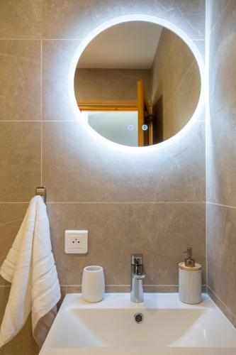 une salle de bain avec un lavabo et un miroir dans l'établissement Perfectly placed petite pad!, à Morzine
