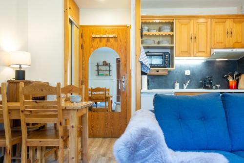 un salon avec un canapé bleu et une table dans l'établissement Perfectly placed petite pad!, à Morzine