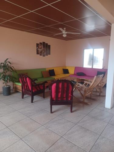 a dining room with a table with colorful chairs at LA DOLCE VITA FRANCOPHONE in Estelí