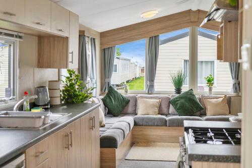 a kitchen and living room with a couch in a caravan at Vacant Nests Seton Sands The Aberlady in Port Seton