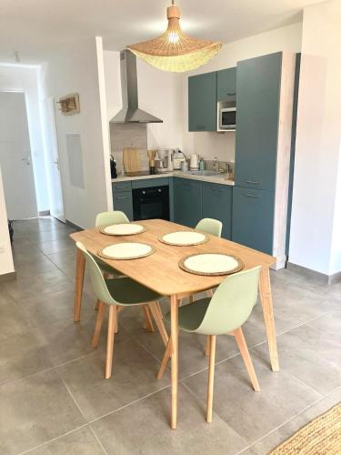 une table de salle à manger avec des chaises et une cuisine dans l'établissement New house 10 min from the beach, à Lit-et-Mixe